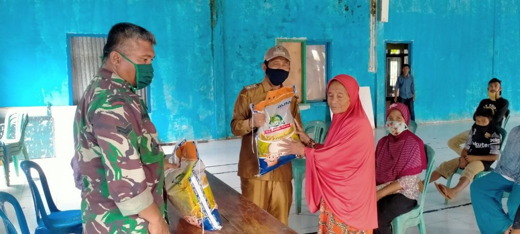Anggota Koramil 1413-13 Lasalimu Kawal Pembagian Beras dan Masker Ke Warga