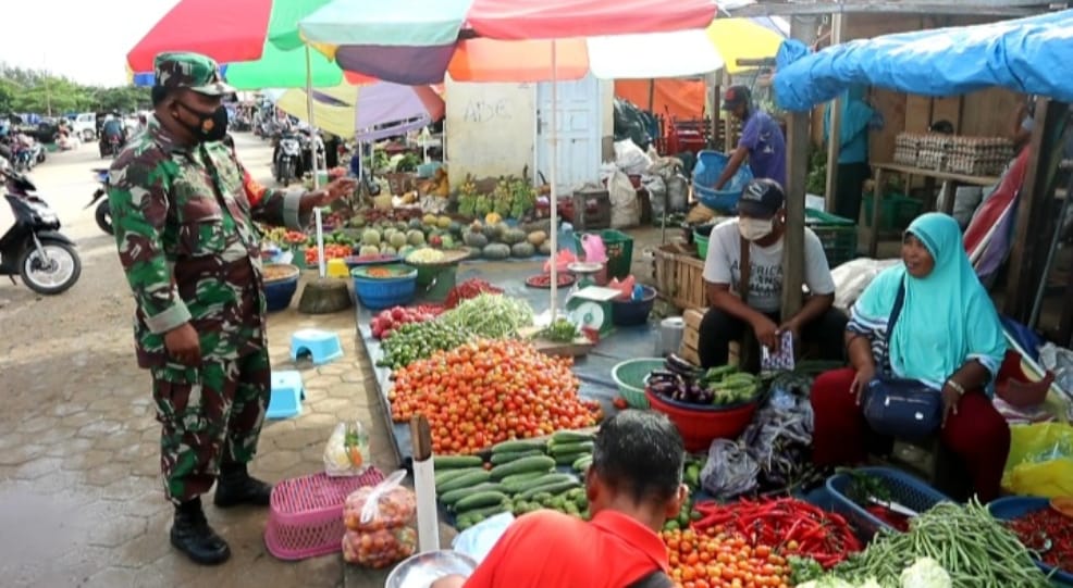 Babinsa Wameo, Serda Bardin saat melakukan komsos bersama para pedagang untuk mematuhi prokes penanganan covid-19 di pasar tradisional Wameo, Sabtu (30/1/2021).
