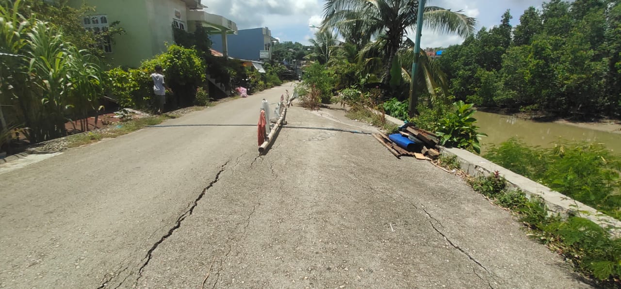 Jalan Tanggul Bataraguru Retak dan Rawan Amblas ke Sungai, Warga Tutup Jalan dengan Pot Bunga dan Kayu Panjang