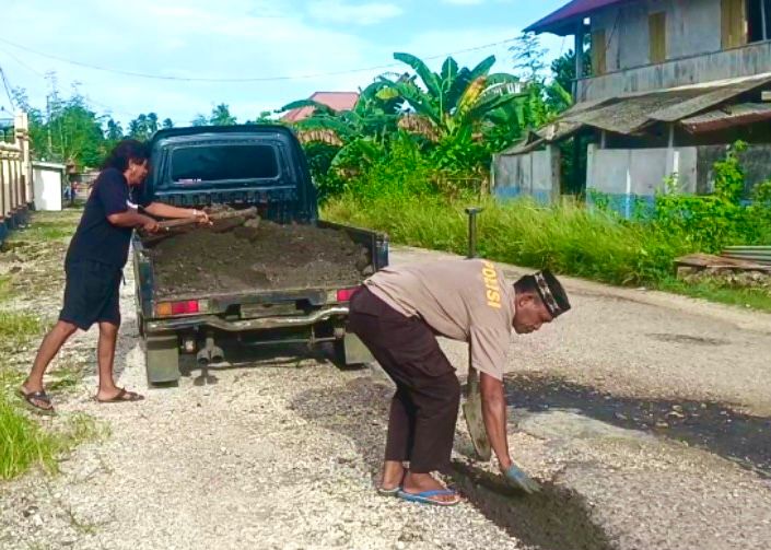 Polisi di Lasalimu Tambal Jalan Berlubang Secara Mandiri, Warga Ikut Gotong Royong